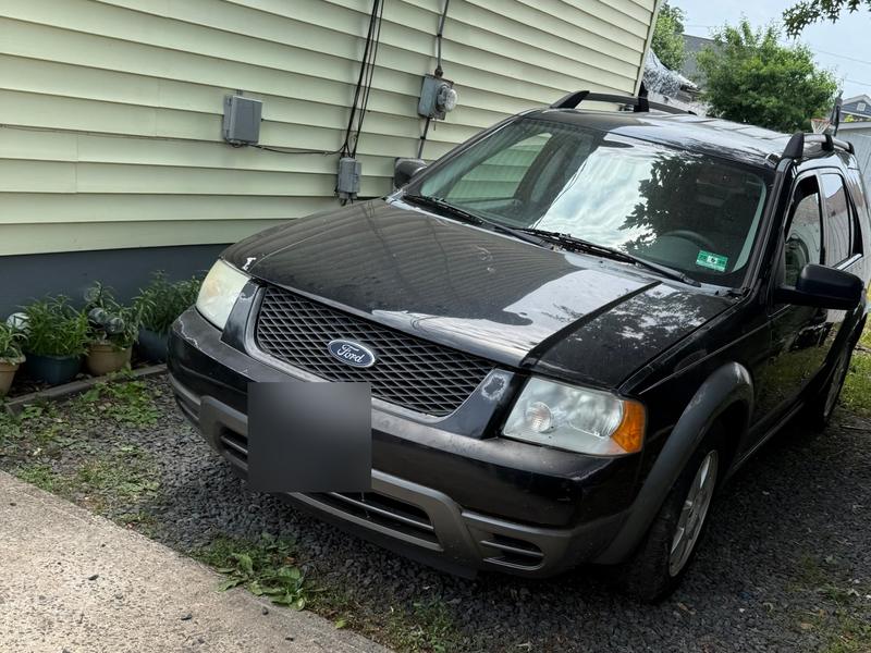 Black Ford Freestyle beside a house bought by Try Auto Way, car buyer in Princeton NJ